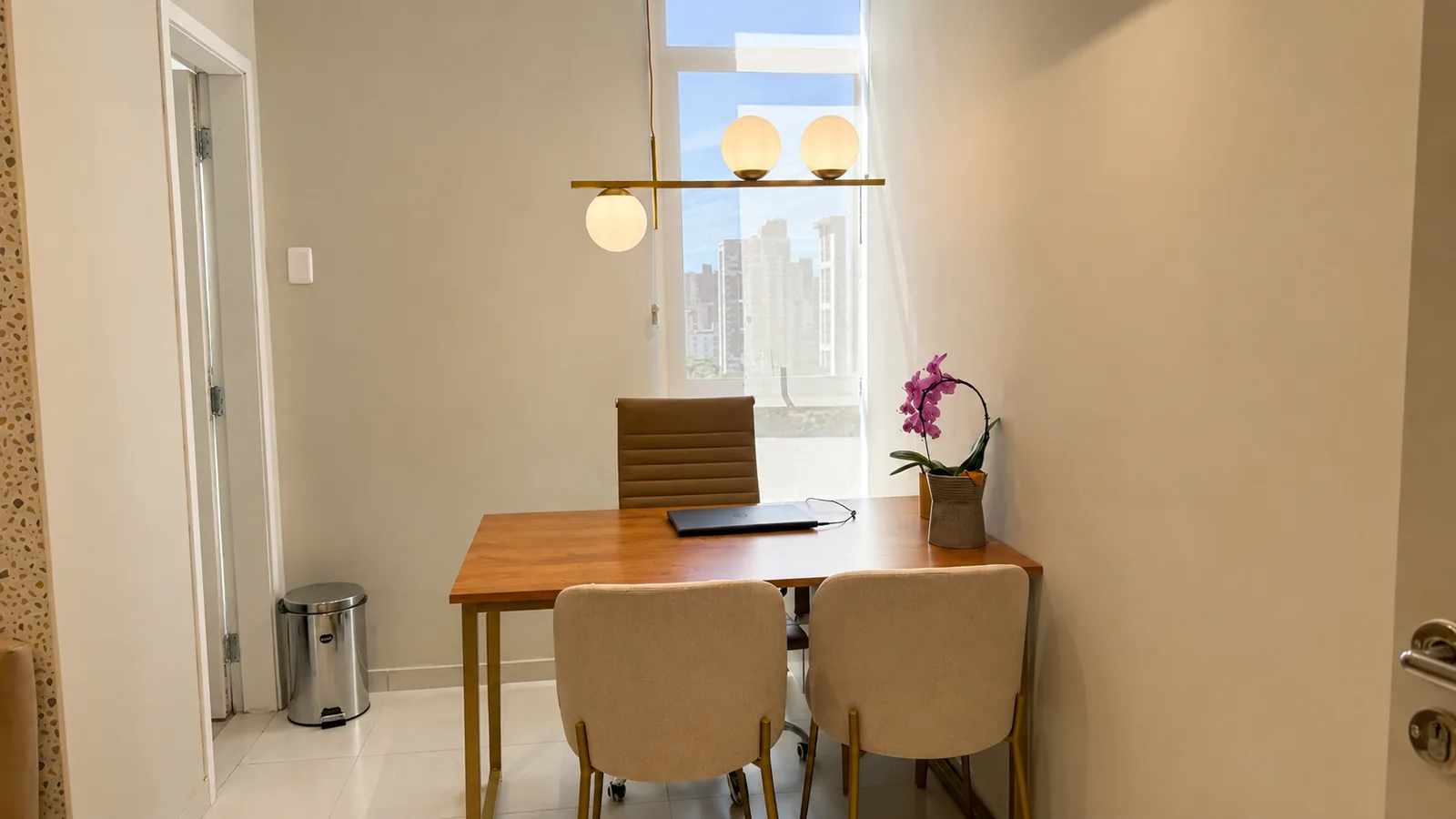Consultório com mesa de madeira junto à janela ampla