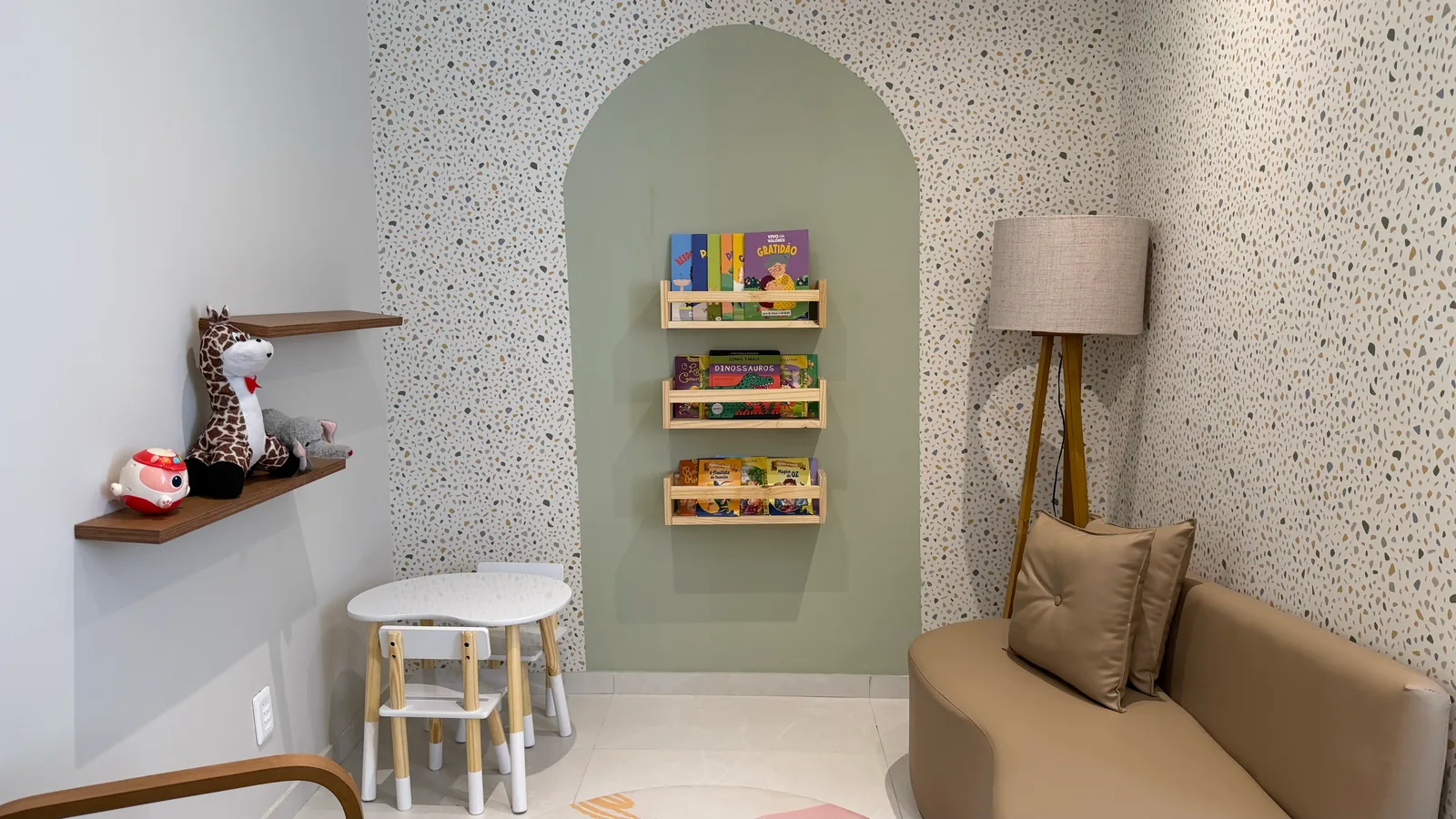 Espaço kids com nicho de leitura, mesa infantil e sofá