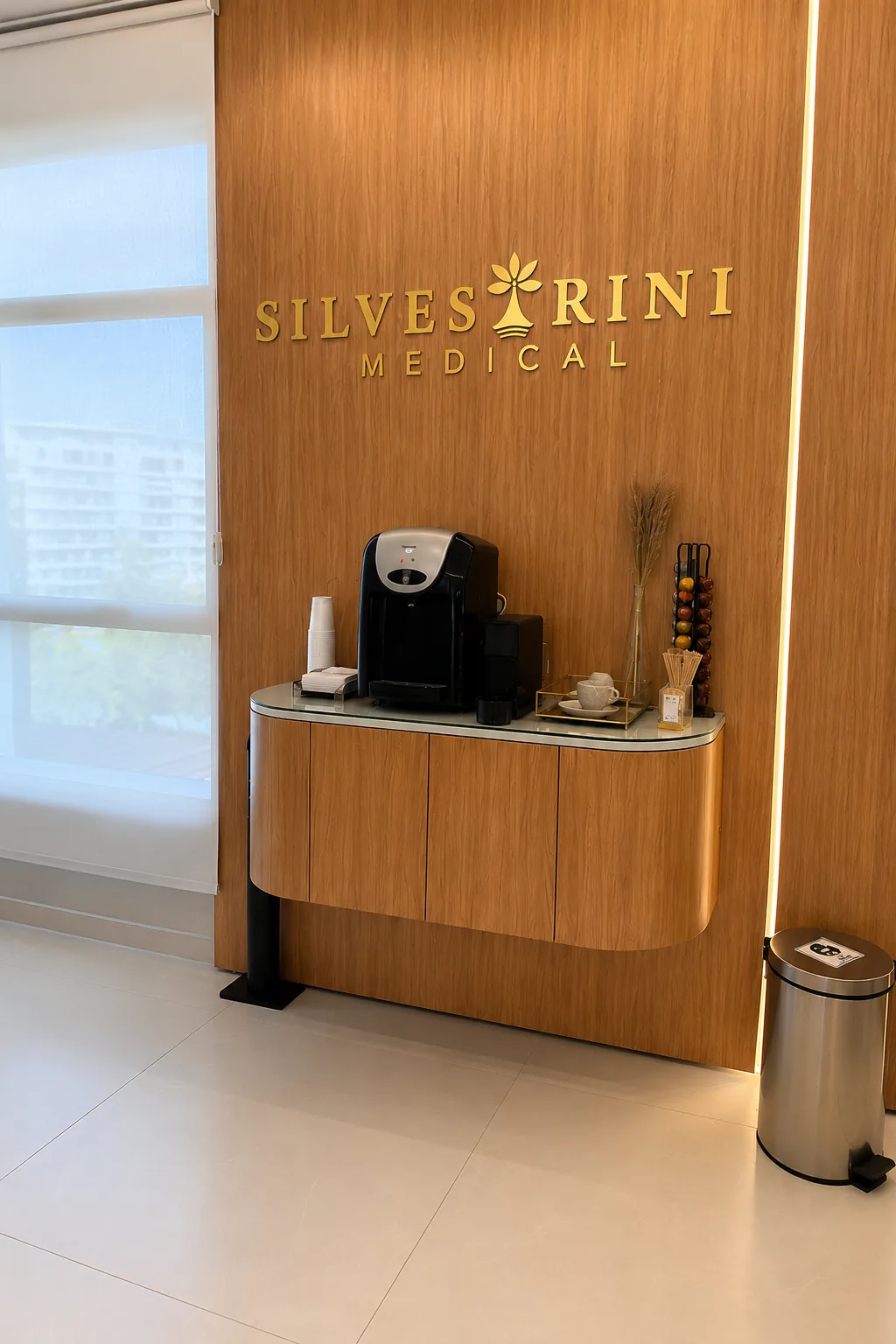 Parede com o letreiro Silvestrini Medical e estação de café