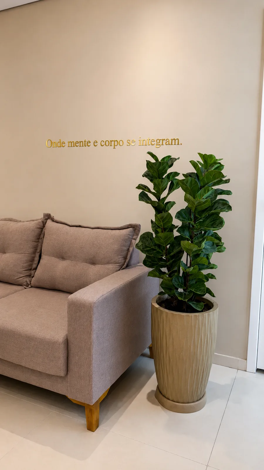 Canto da sala de espera com planta e sofá